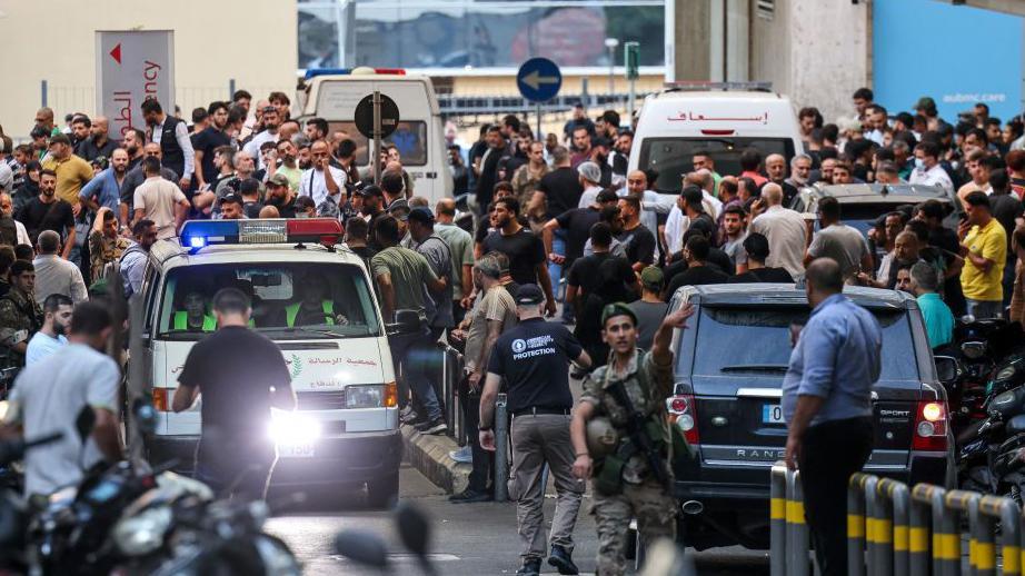 Pessoas reunidas na entrada de um hospital em Beirute.



