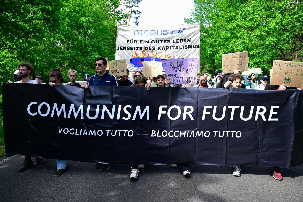 Activistas ambientales marchan frente a una planta deTesla en Gruenheide, al sureste de Berlín, el 11 de mayo de 2024, para protestar contra los planes de la compañía de talar los árboles para ampliar la fábrica.