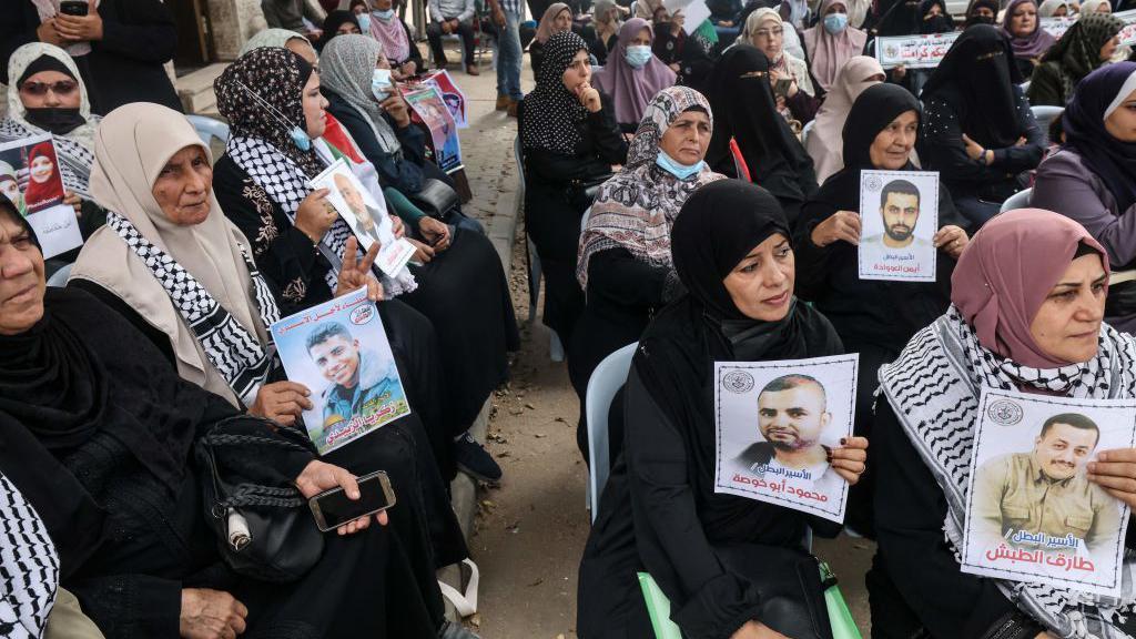 نساء فلسطينيات يحملن صور أقاربهن المعتقلين في سجون الاحتلال الإسرائيلي (صورة أرشيفية).