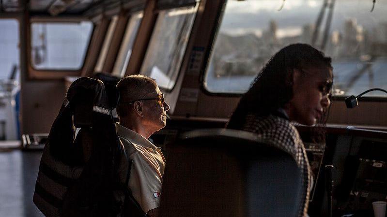 Mulher e homem em frente a janela de navio