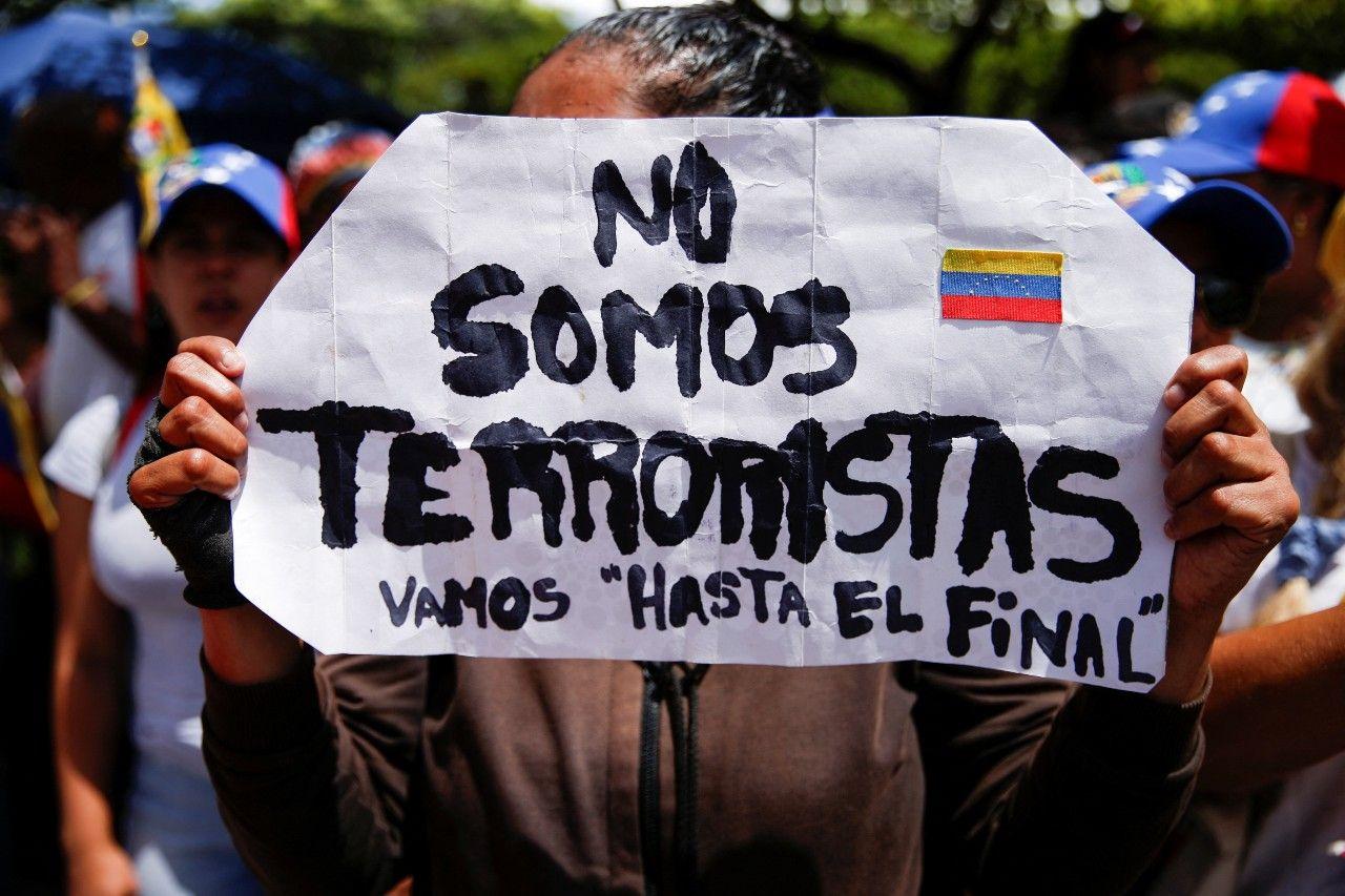 Manifestante segurando cartaz em protesto: 'Não somos terroristas'