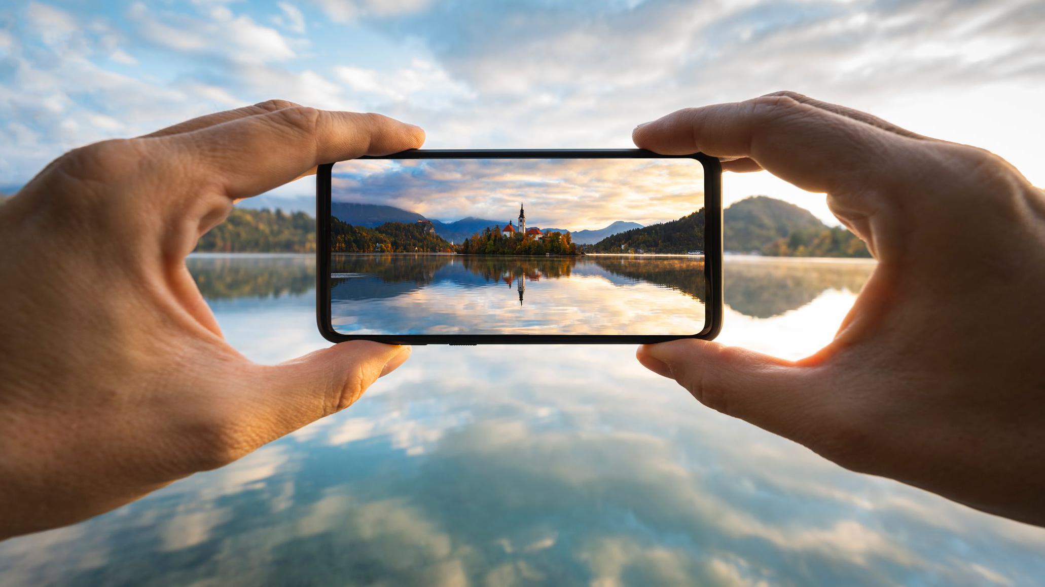 Mãos segurando um smartphone e tirando uma foto 