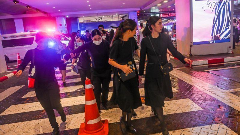 Orang-orang menyeberang jalan menuju pusat perbelanjaan