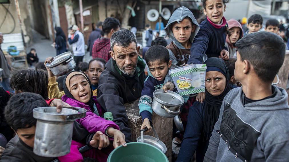 Personas en Gaza pidiendo comida