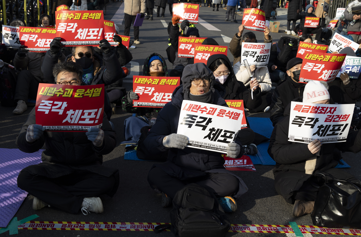 윤석열 대통령 관저 주변에 모인 집회자들이 윤석열 대통령 체포를 요구하는 펫말을 들고 있다