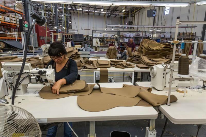 Mulher costura tecidos em uma máquina industrial 