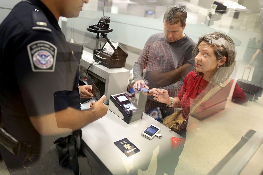 Un agente del CBP entrevista a dos viajeros en EE.UU.