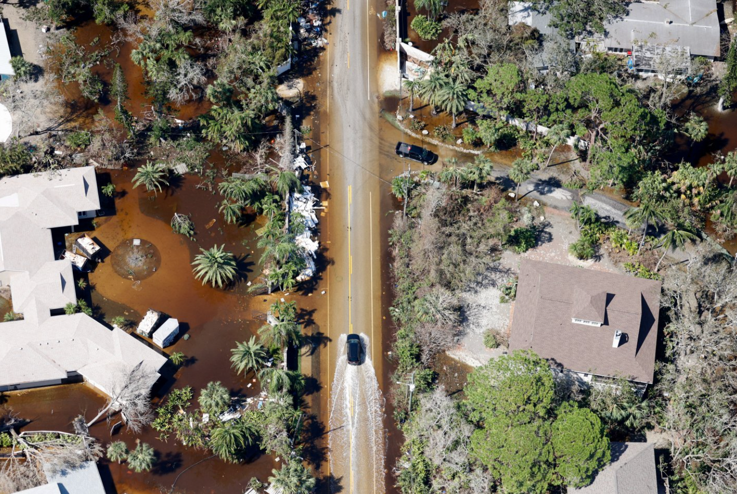 Pemandangan udara memperlihatkan mobil-mobil melaju melalui jalan-jalan yang banjir setelah Badai Milton menerjang daratan, di Siesta Key, Florida, AS, pada 10 Oktober 2024.