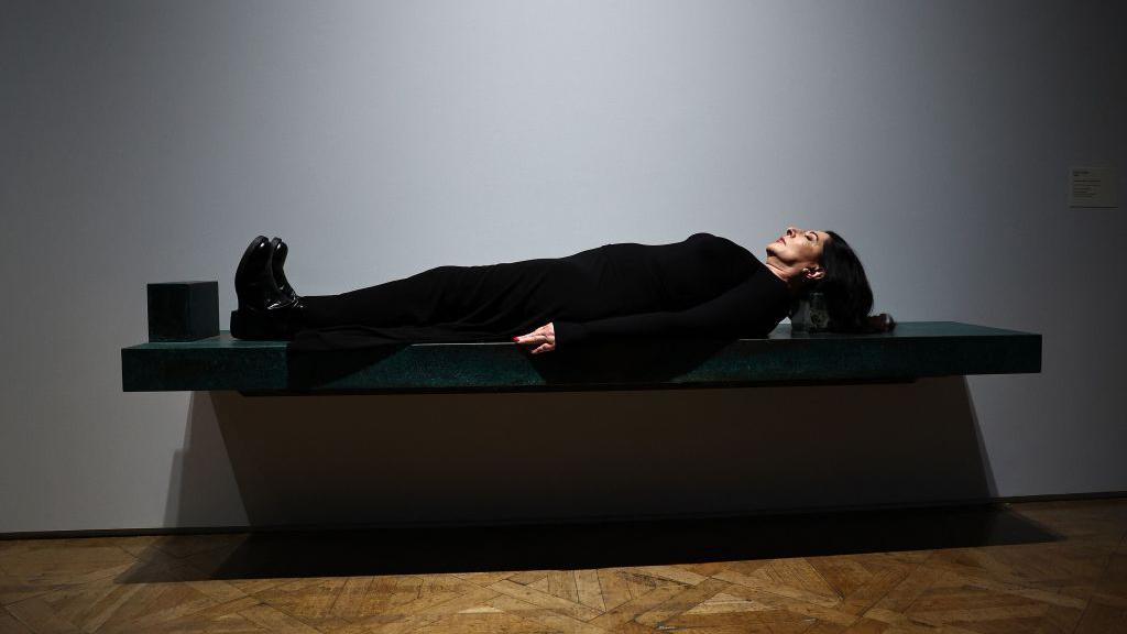 Marina Abramovic posa sobre una de sus obras de arte, titulada "Dragón Verde" durante una sesión fotográfica en la Royal Academy of Arts (RA).