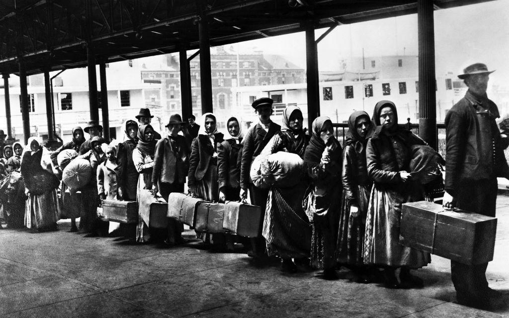 Inmigrantes hacen fila en el centro de procesamiento de extranjeros de Ellis Island, Nueva York. 