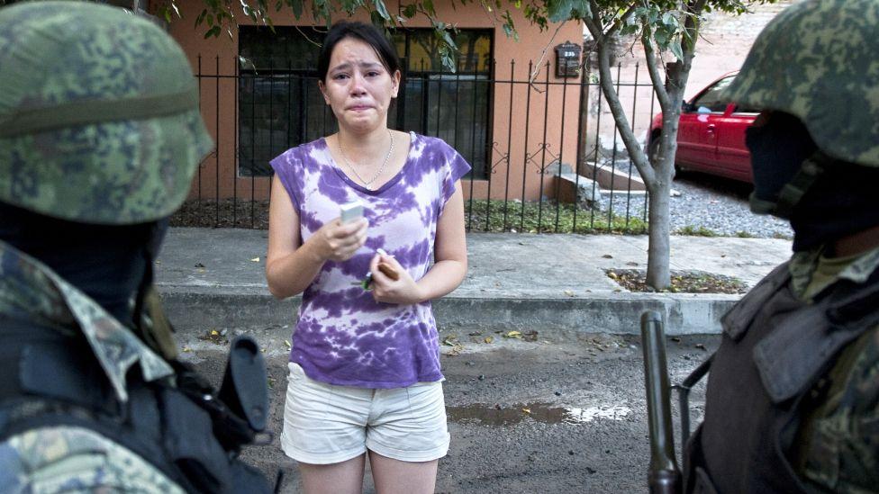 Mulher de Tampico afetada pela violência falando com militares na rua.