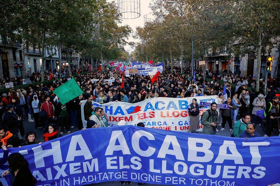 Manifestantes con una pancarta que dice: "Se acabó. Bajamos los alquileres".