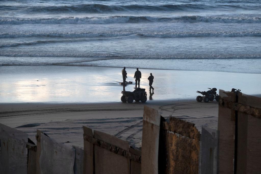 Agentes fronterizos de EE.UU. frente a un cadáver que llegó a las costas de su país.