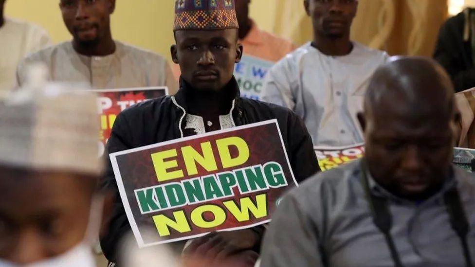 Ativista segurando cartaz que pede o fim dos sequestros