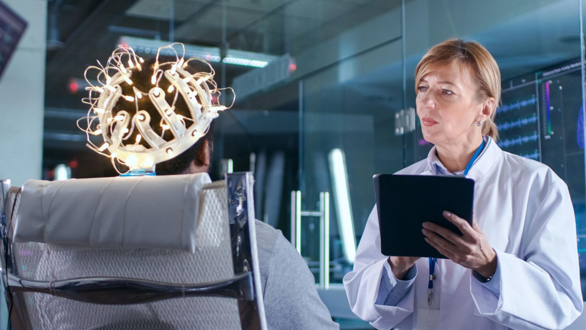 Una científica observa a un paciente con electrodos en la cabeza
