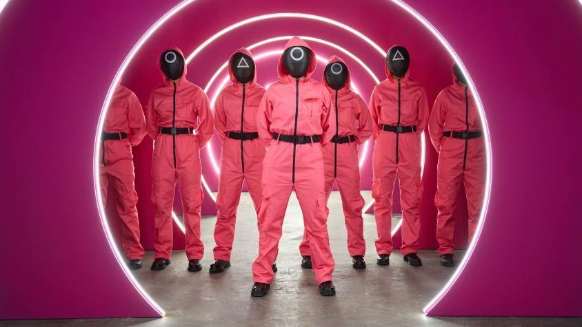 Personagens que fazem o papel de segurança na série posam durante premiê de Round 6