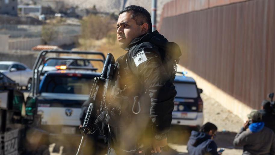 Policías mexicanos frente al muro fronterizo