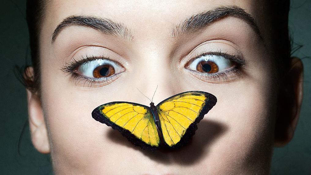 Mujer con mariposa en la nariz