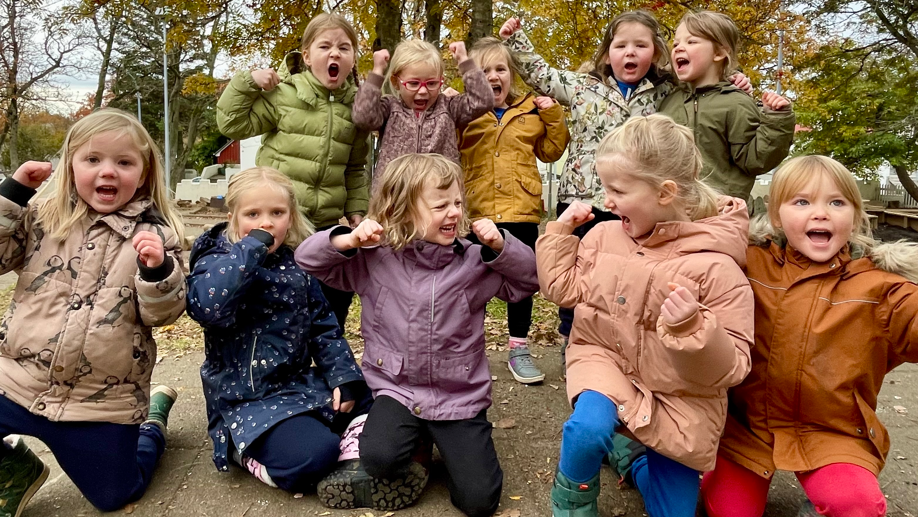 Un grupo de 10 niñas en el jardín mostrando que son fuertes.