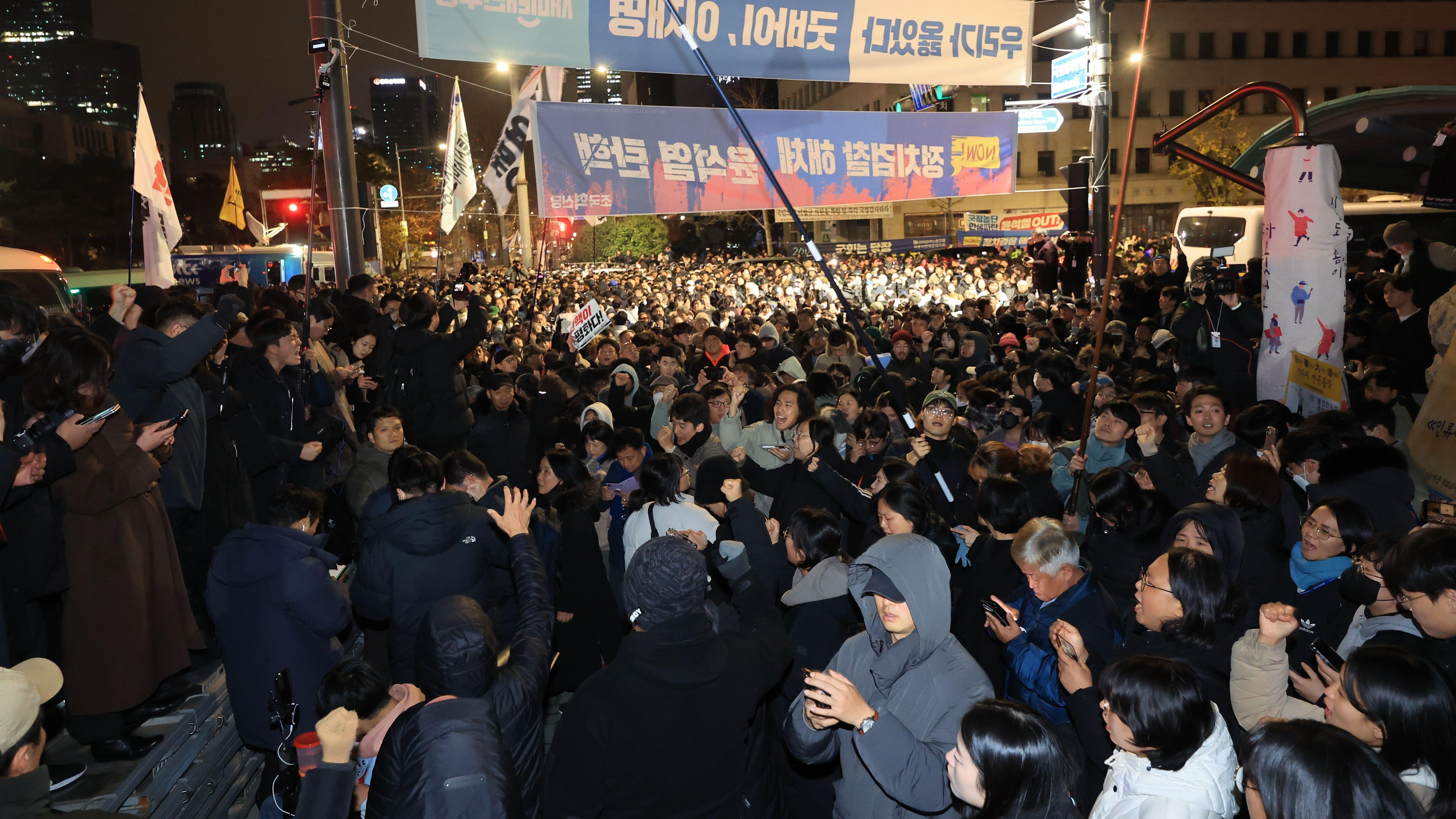 Gente se reúne frente a la Asamblea Nacional en Seúl, Corea del Sur, en la madrugada del 4 de diciembre de 2024, exigiendo el levantamiento de la ley marcial.