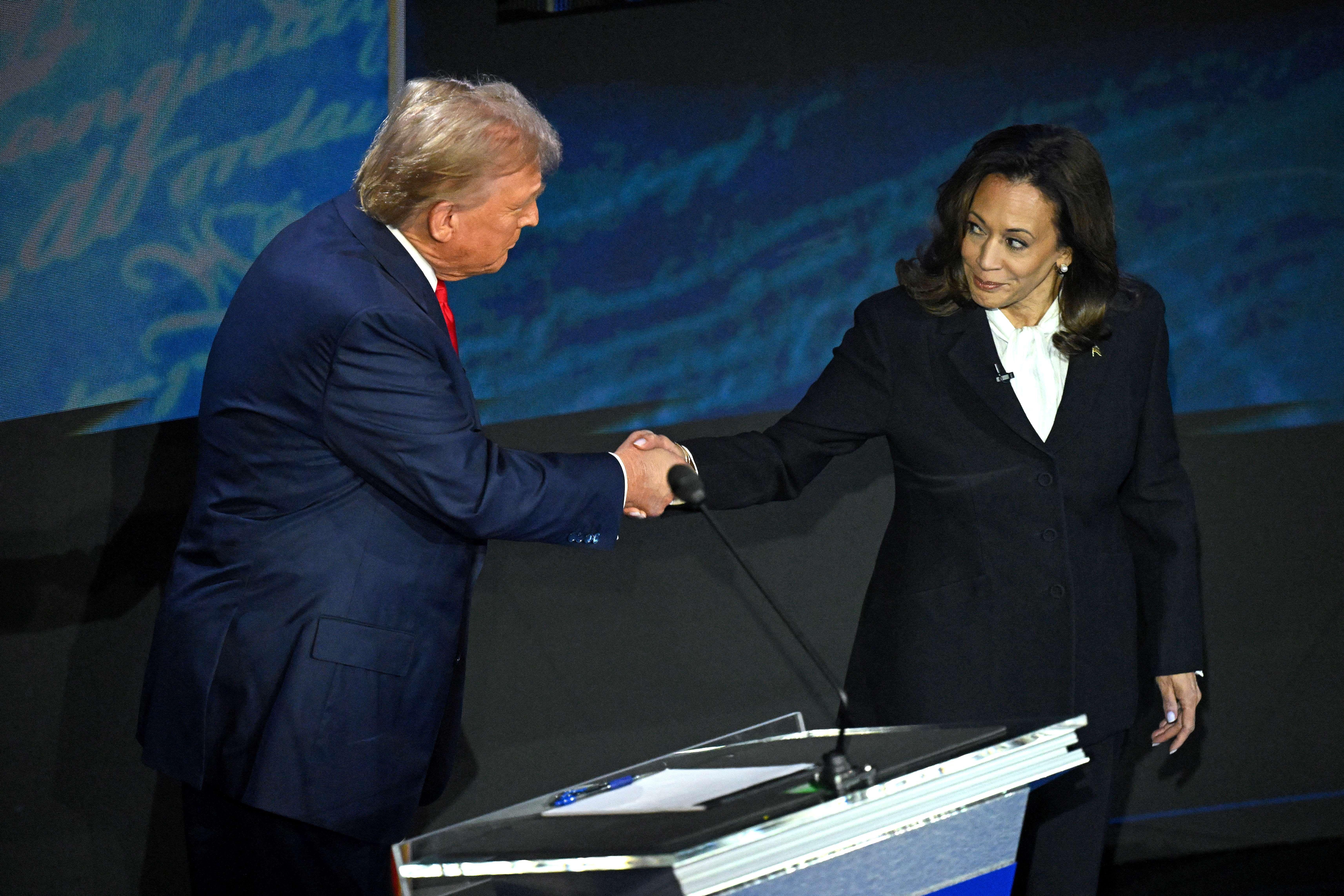 Donald Trump y Kamala Harris se saludan con un apretón de manos mirándose a los ojos durante su debate de septiembre.