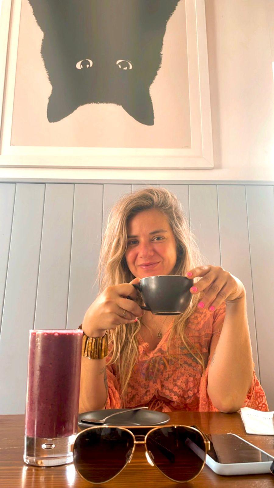 Amanda Munaretti Selbach sentada com uma xícara na mão