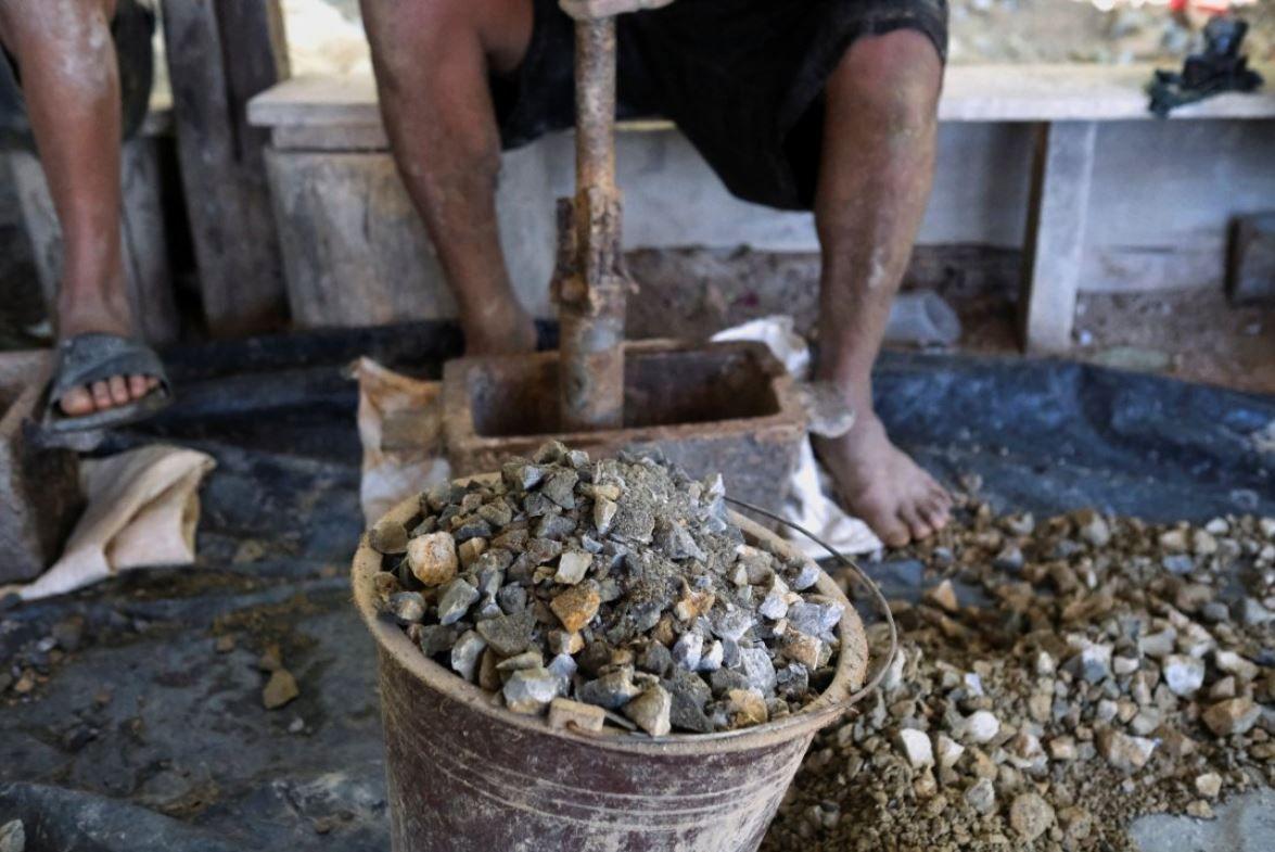 Unos "guiriseros", el nombre con el que se conoce a los mineros artesanales, frente a unas pepitas de mineral de oro sacadas de socavones que cavan en la mina abandonada de San Sebastián, en Santa Rosa de Lima, departamento de La Unión, El Salvador, el 17 de diciembre de 2024. REUTERS/José Cabezas
