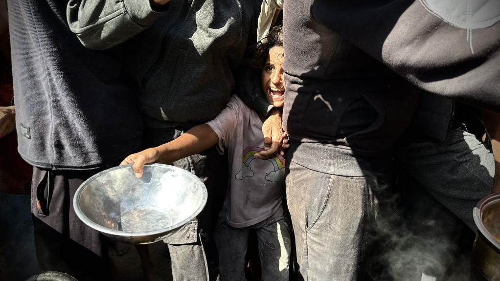 Seorang bocah Palestina mengantre makanan yang didistribusikan oleh organisasi amal kepada pengungsi yang berlindung di Khan Yunis, Gaza, pada 28 Oktober 2024