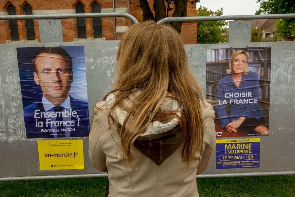 mulher olha posteres de candidatos à presidência na França