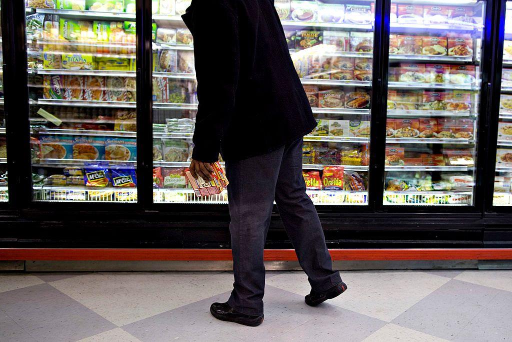 Hombre delante de los refrigeradores con comida ultraprocesada en un supermercado de Estados Unidos.