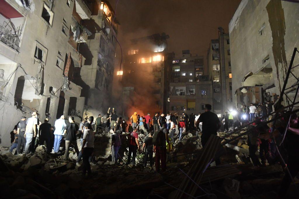 Un grupo de gente entre edificios en ruinas en Beirut el jueves 10 de octubre.