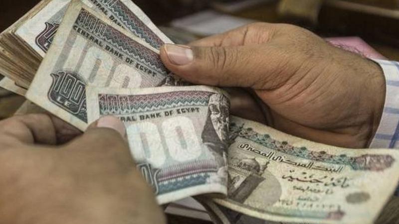 رجل يقوم بعد نقود بالعملة المصرية الجنيه