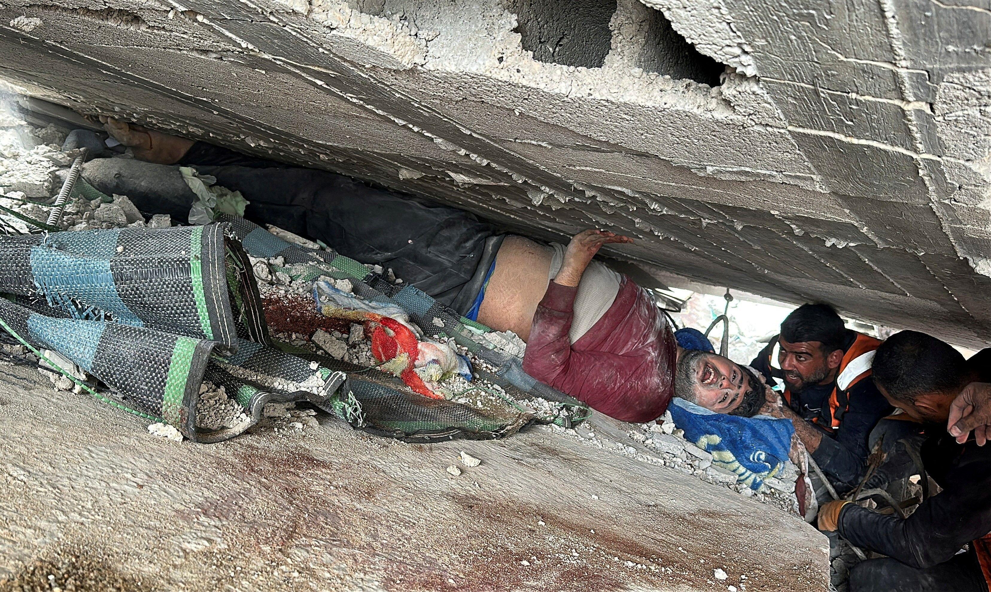 محاولة إنقاذ رجل فلسطيني تحت الأنقاض في غارة إسرائيلية على مربع سكني في حي الشجاعية في 9 أبريل/نيسان 2025.