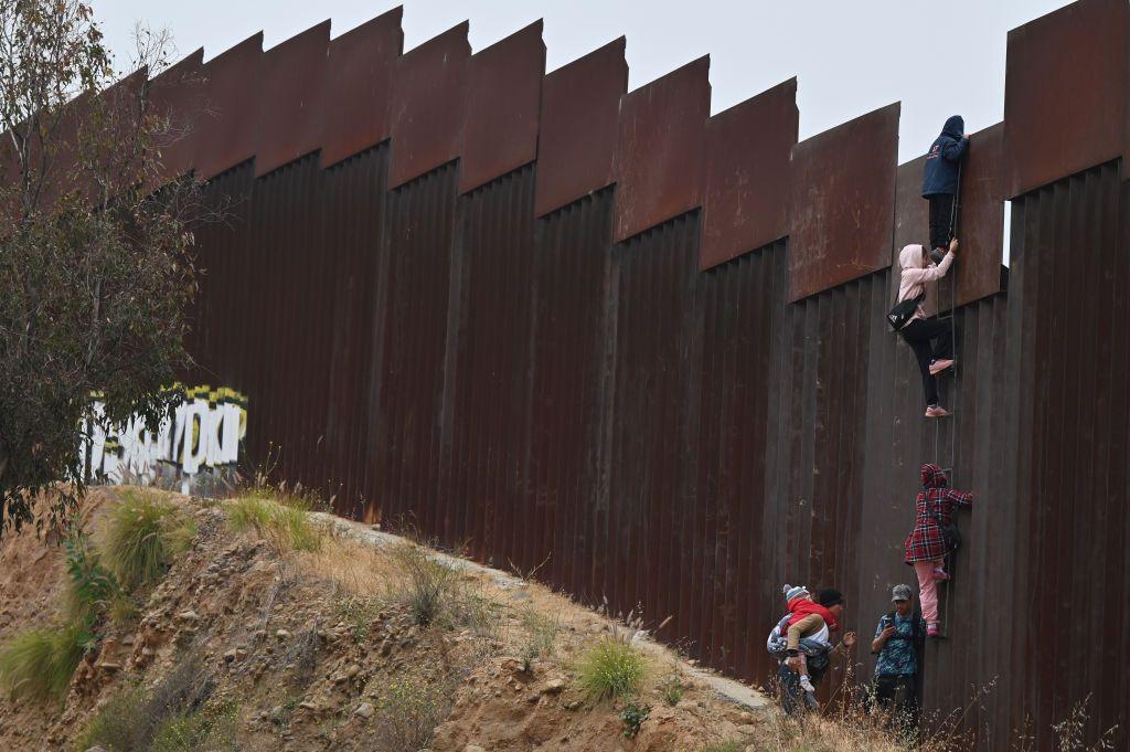 Migrantes pasando la frontera entre Tijuana y San Diego