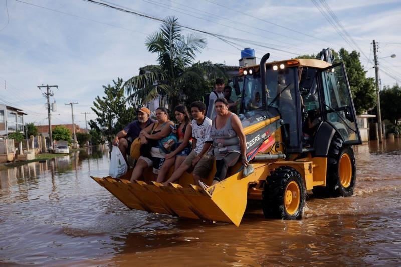 Pessoas sendo resgatadas de trator