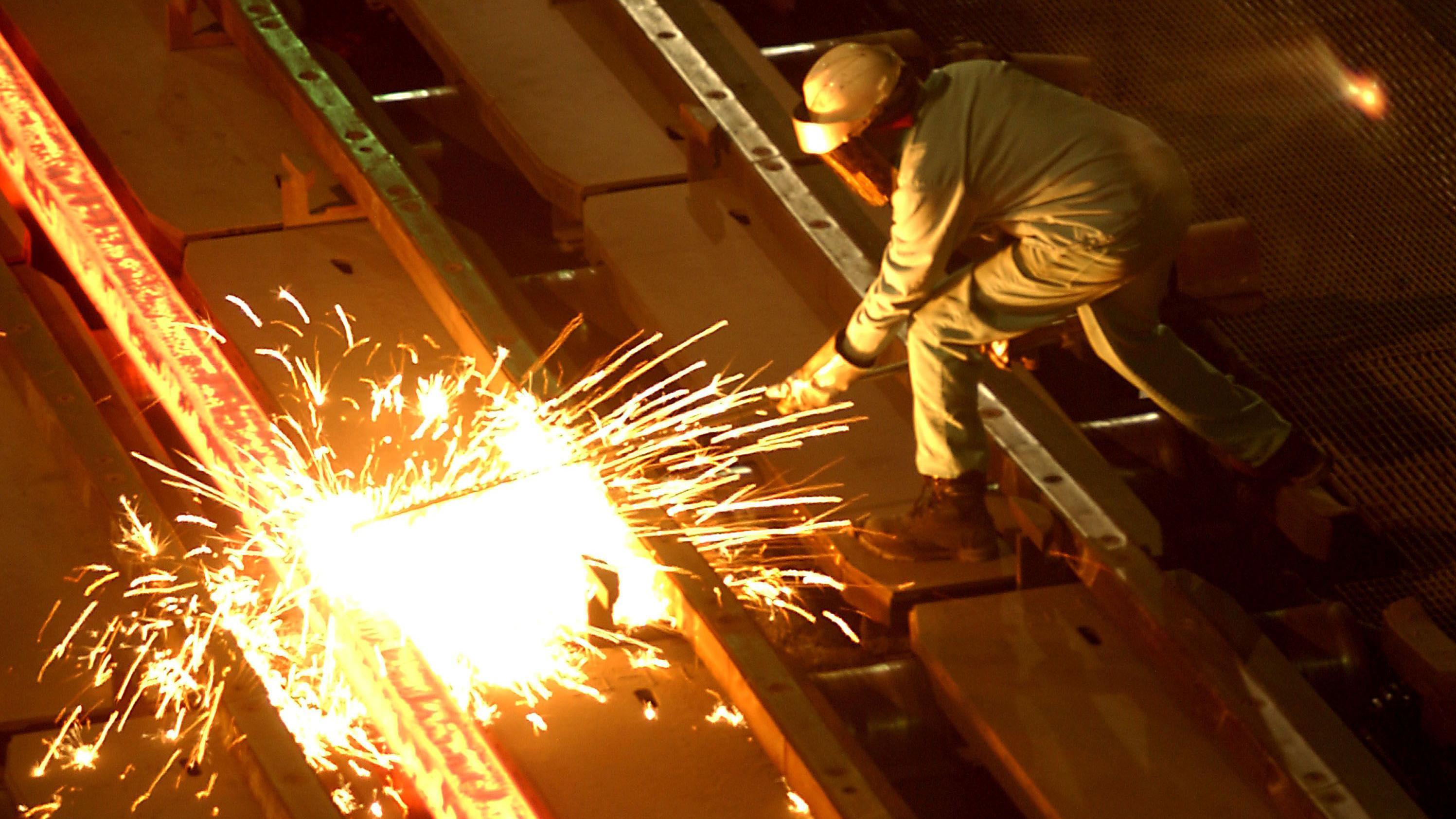 A worker cuts molten steel at a mill in California