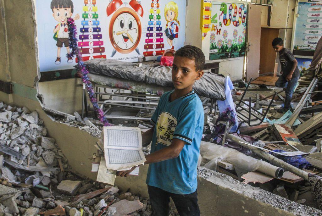 فلسطينيون يتفقدون الأضرار التي لحقت بمدرسة تابعة للأونروا تعرضت لهجوم إسرائيلي على مخيم الشاطئ للاجئين في قطاع غزة في 25 يونيو/حزيران 2024