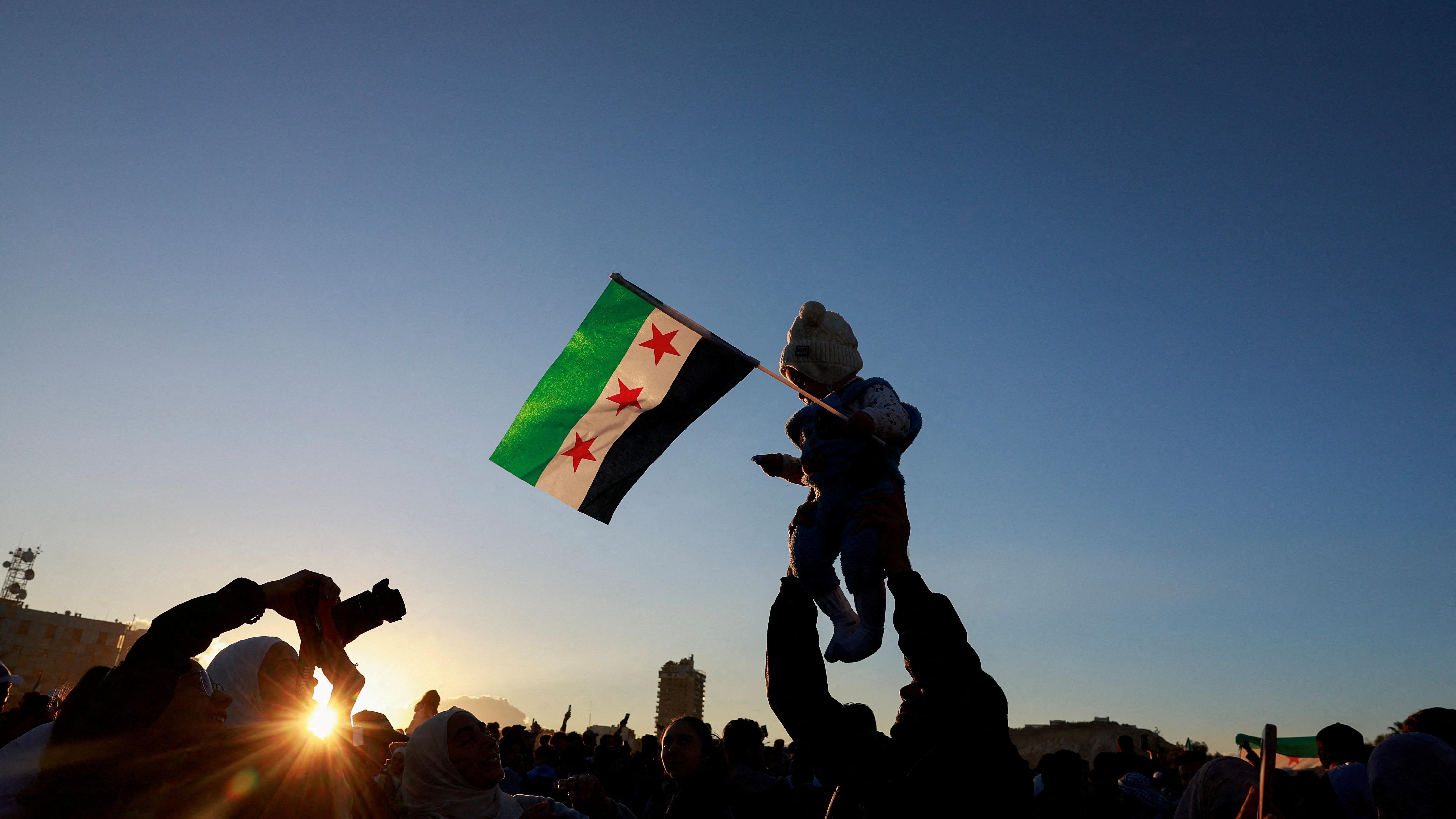 طفل يحمل علم "الثورة" السوري