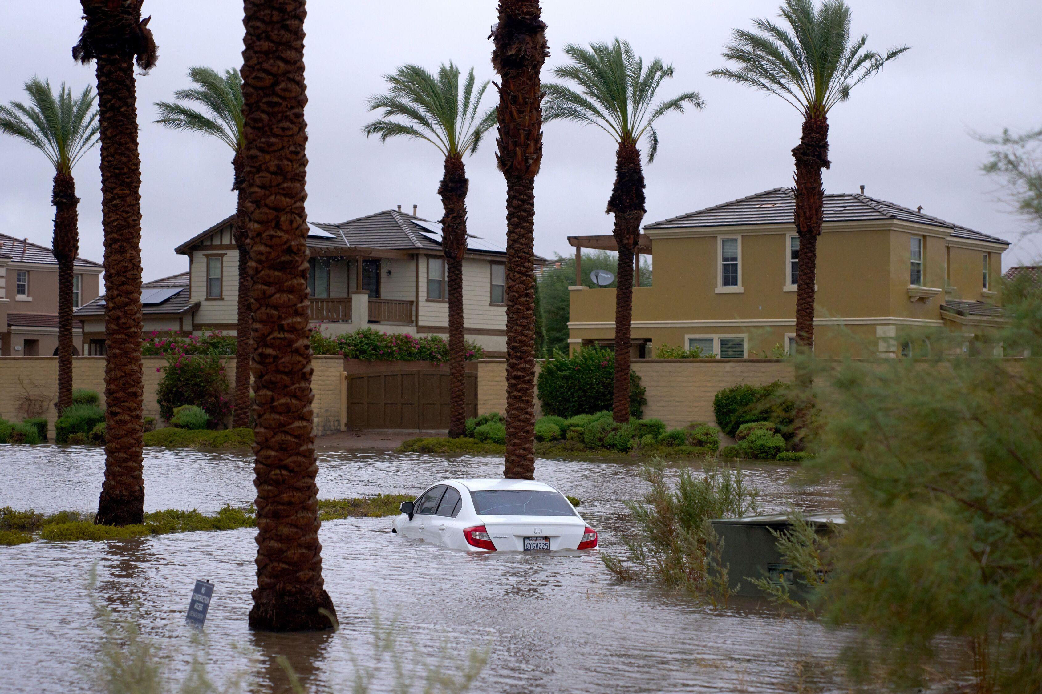 Un automóvil sumergido en una calle inundada tras el paso de la tormenta tropical Hilary en Cathedral City, California.