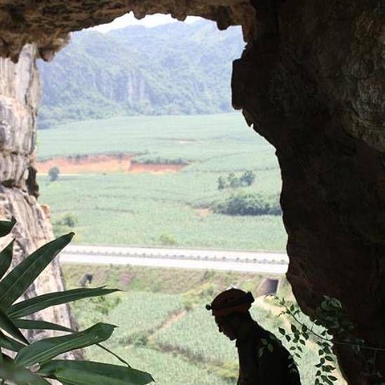 La silueta de uno de los científicos en la entrada de una cueva a 150 metros de altura