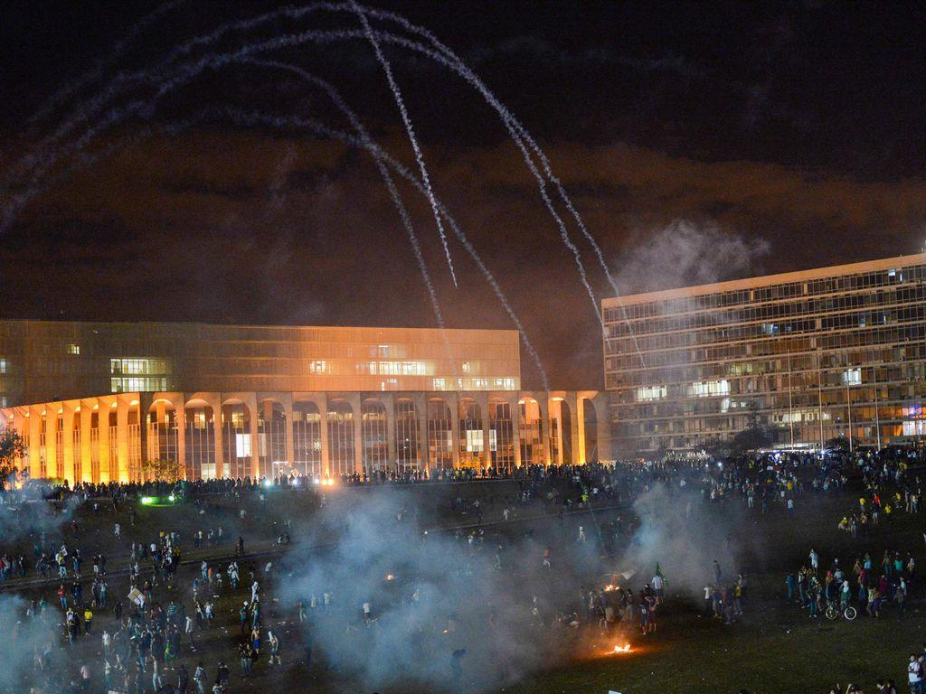 Policiais jogando bombas de gás contra manifestantes em Brasília