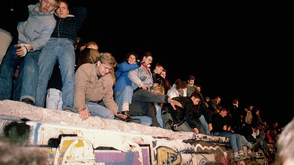 Jóvenes encaramados en el Muro de Berlín, 9 de noviembre 1989