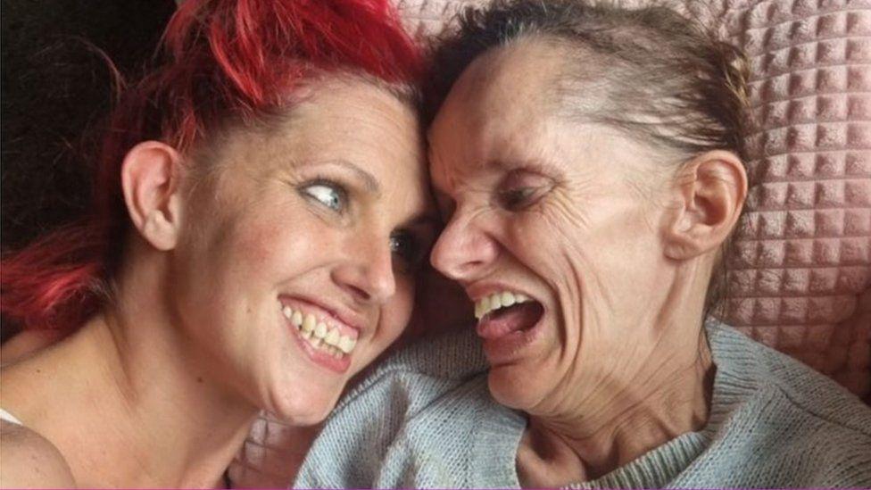 Two women smile at each other