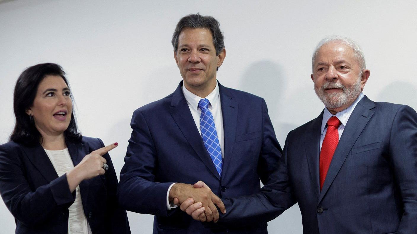 Tebet, Haddad e Lula posando para foto em frente a parede