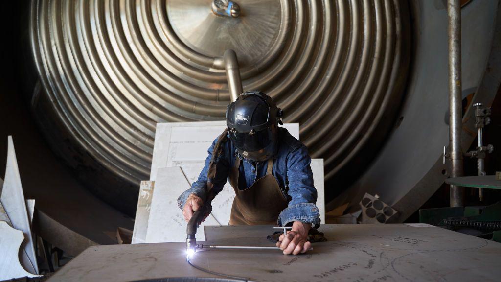 Un trabajador corta una lámina de acero inoxidable en una planta de fabricación de acero en la Ciudad de México, México.