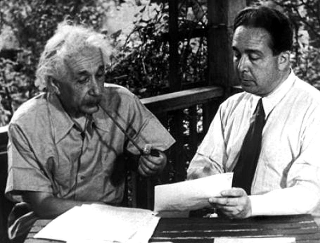 Einstein e Leo Szilard sentados olhando um papel