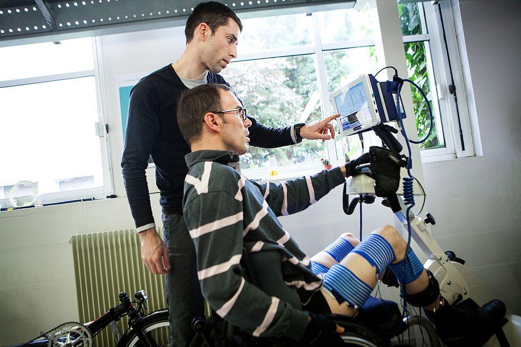 Um técnico ajusta um dispositivo de interface cérebro-máquina para um paciente paraplégico
