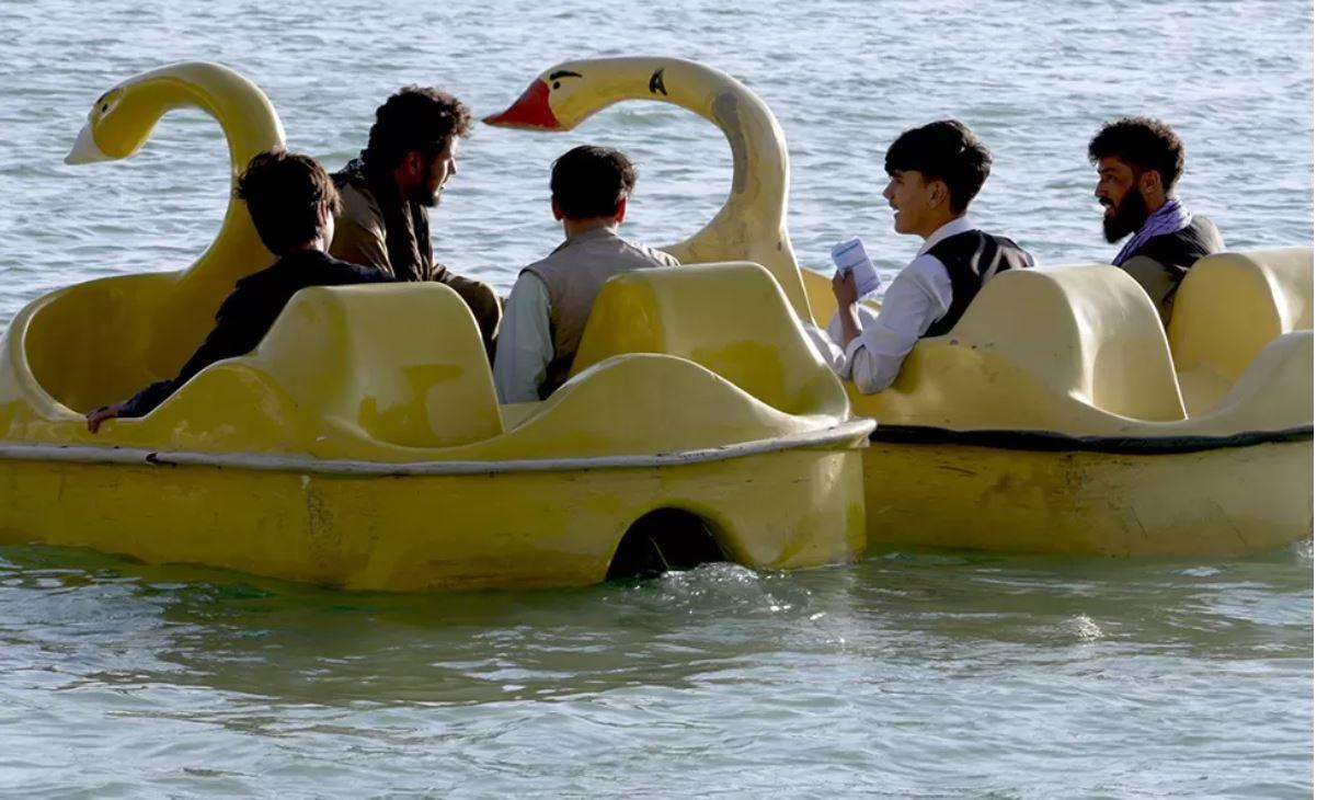 رجلان مع ابنائهما على قاربين في بحير قراغا في أغسطس/آب 2023