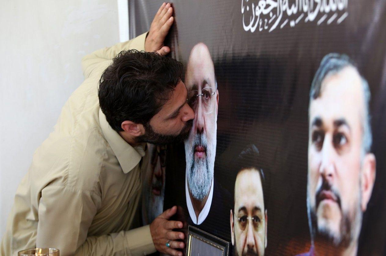إيراني يقبل صورة رئيسي