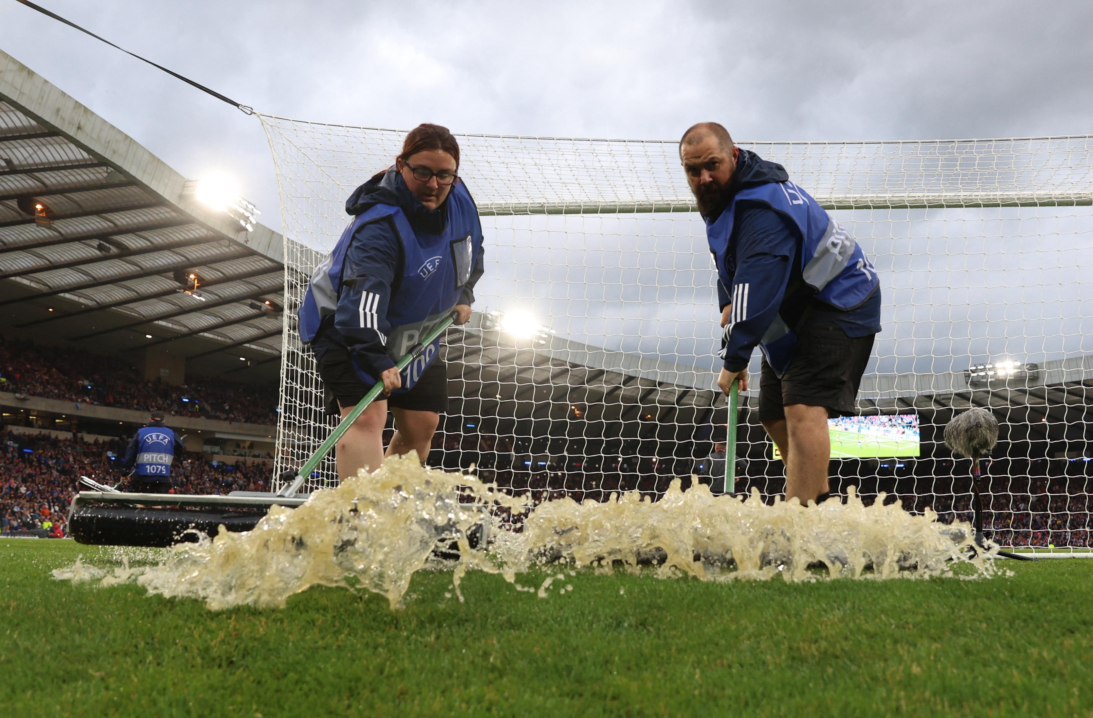 إزالة مياه الأمطار من أرض ملعب هامبدن بارك، غلاسكو، اسكتلندا، أثناء توقف المباراة بسبب سوء الأحوال الجوية خلال تصفيات أمم أوروبا في 20 يونيو/حزيران 2023